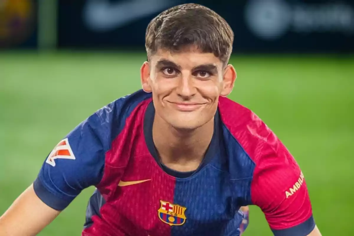 Un jugador de futbol amb la samarreta del FC Barcelona somriu mentre s'inclina cap endavant en un camp de joc.