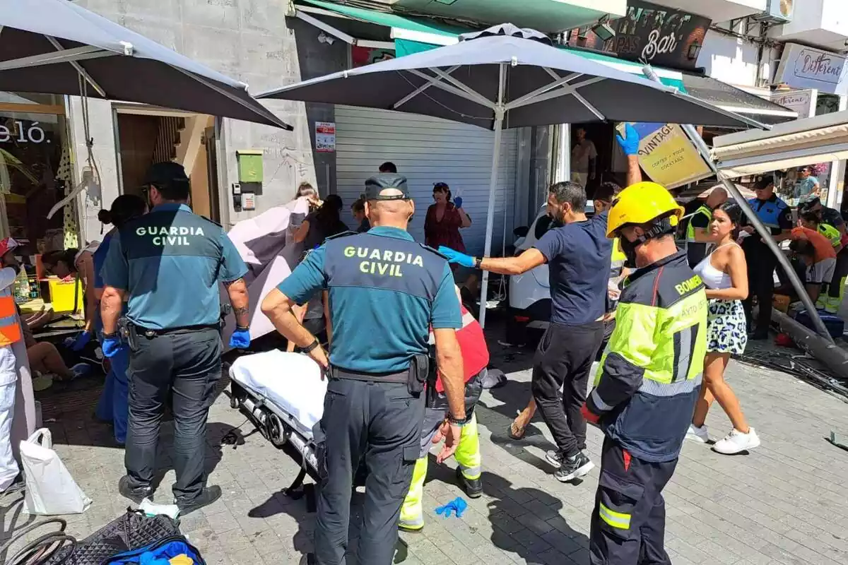 Guàrdia Civil i els Bombers amb sanitaris atenent les víctimes d'un atropellament