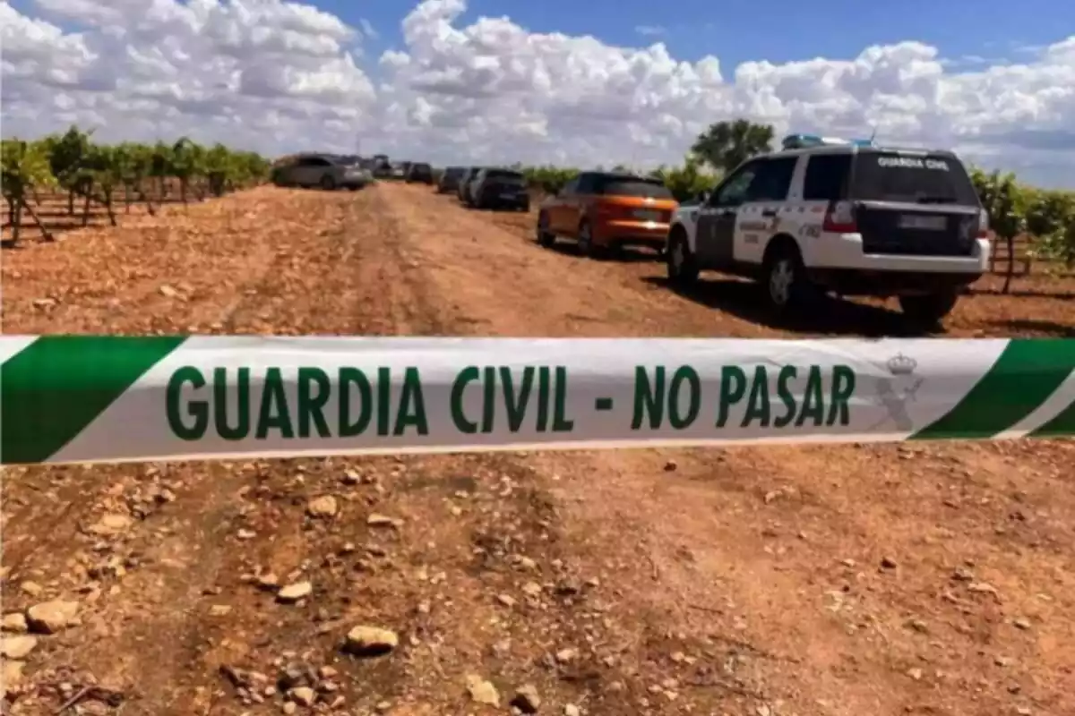 Camí de terra amb cotxe de la Guàrdia Civil al costat d'altres cotxes i cordó de la Guàrdia Civil