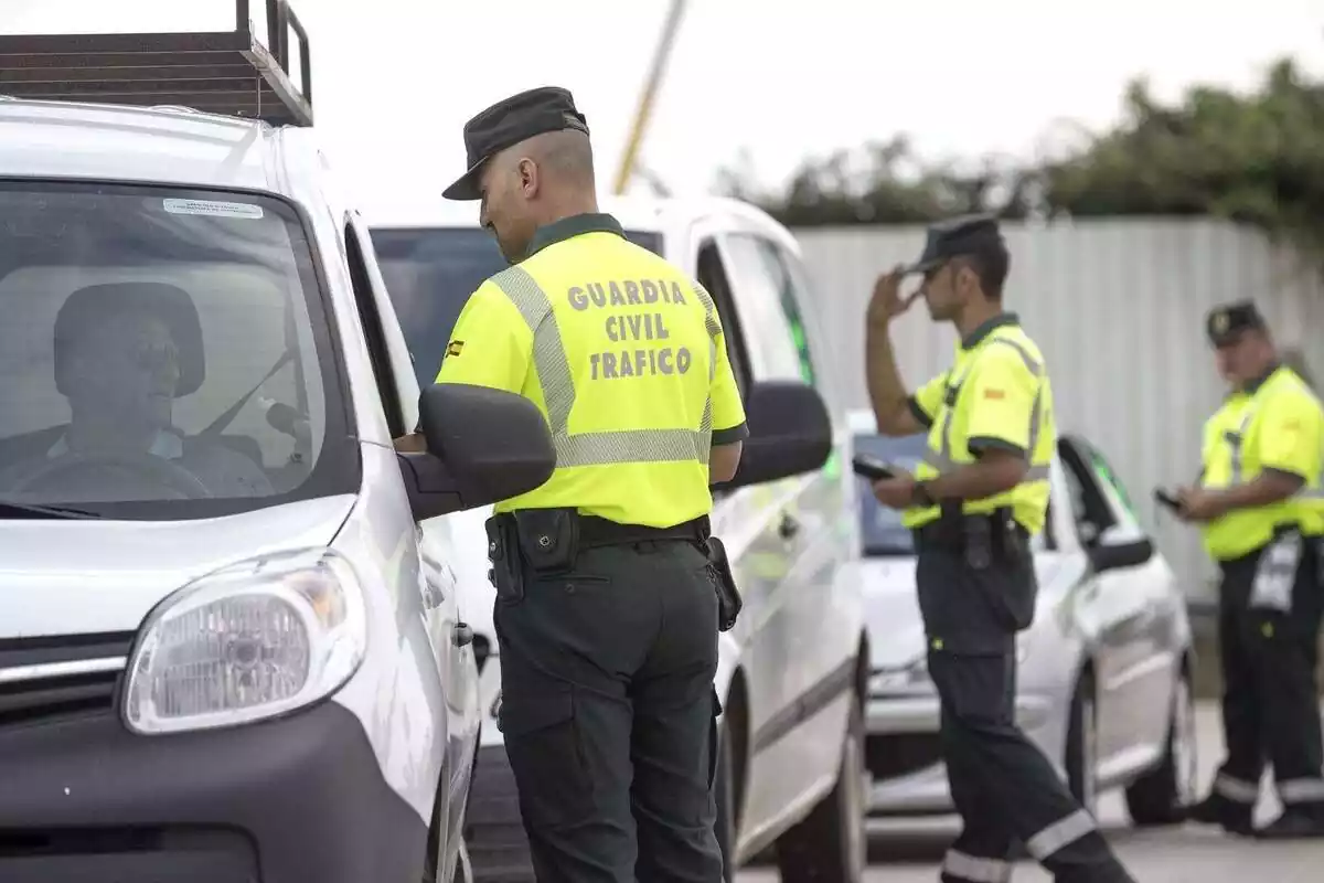 Diversos Guàrdia Civils de trànsit parant cotxes en un control