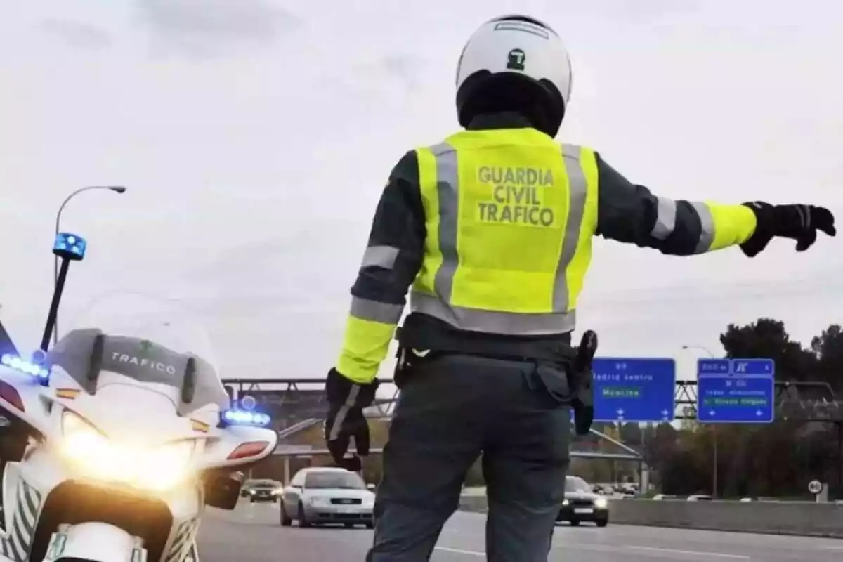 Un Guàrdia Civil de trànsit en una moto parant cotxes en una autovia