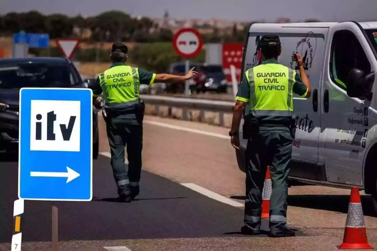 Uns agents de la Guàrdia Civil detenen uns vehicles en un control de carretera, amb un senyal de la ITV