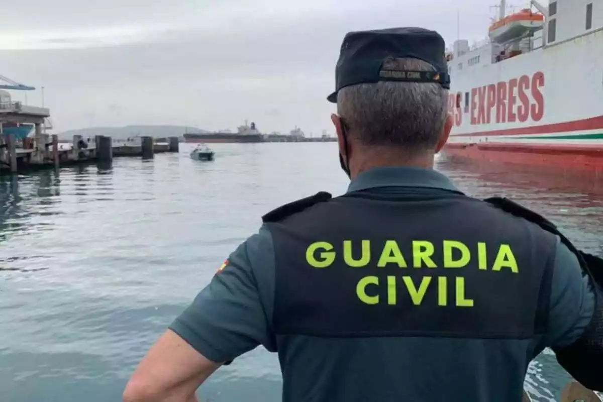 Guàrdia Civil, d'esquena, a un port marítim
