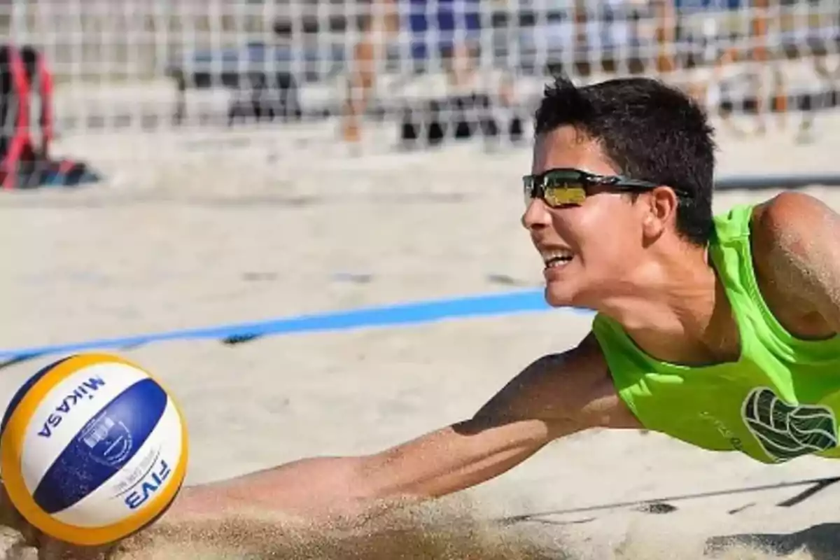 Jugador de voleibol de platja llançant-se per colpejar la pilota. Jugador de voleibol de platja llançant-se per colpejar la pilota.