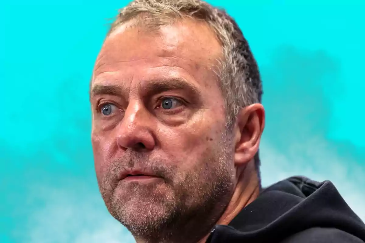 Middle-aged man with a short beard and gray hair looking straight ahead with a serious expression against a turquoise blue background.
