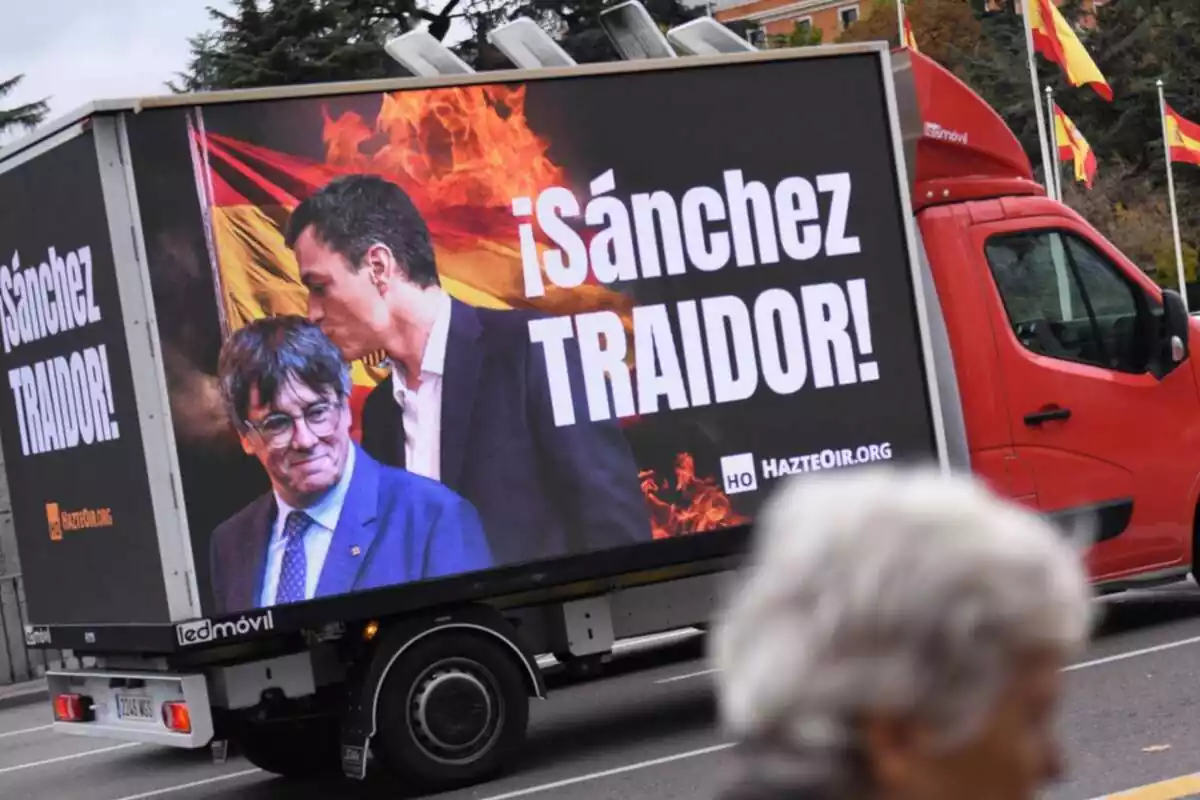 Camió de Fes-te Sentir recorrent un carrer de Madrid amb una pantalla gegant en què es llegeix el lema Sánchez traïdor! amb una foto de Pedro Sánchez besant al cap Carles Puigdemont