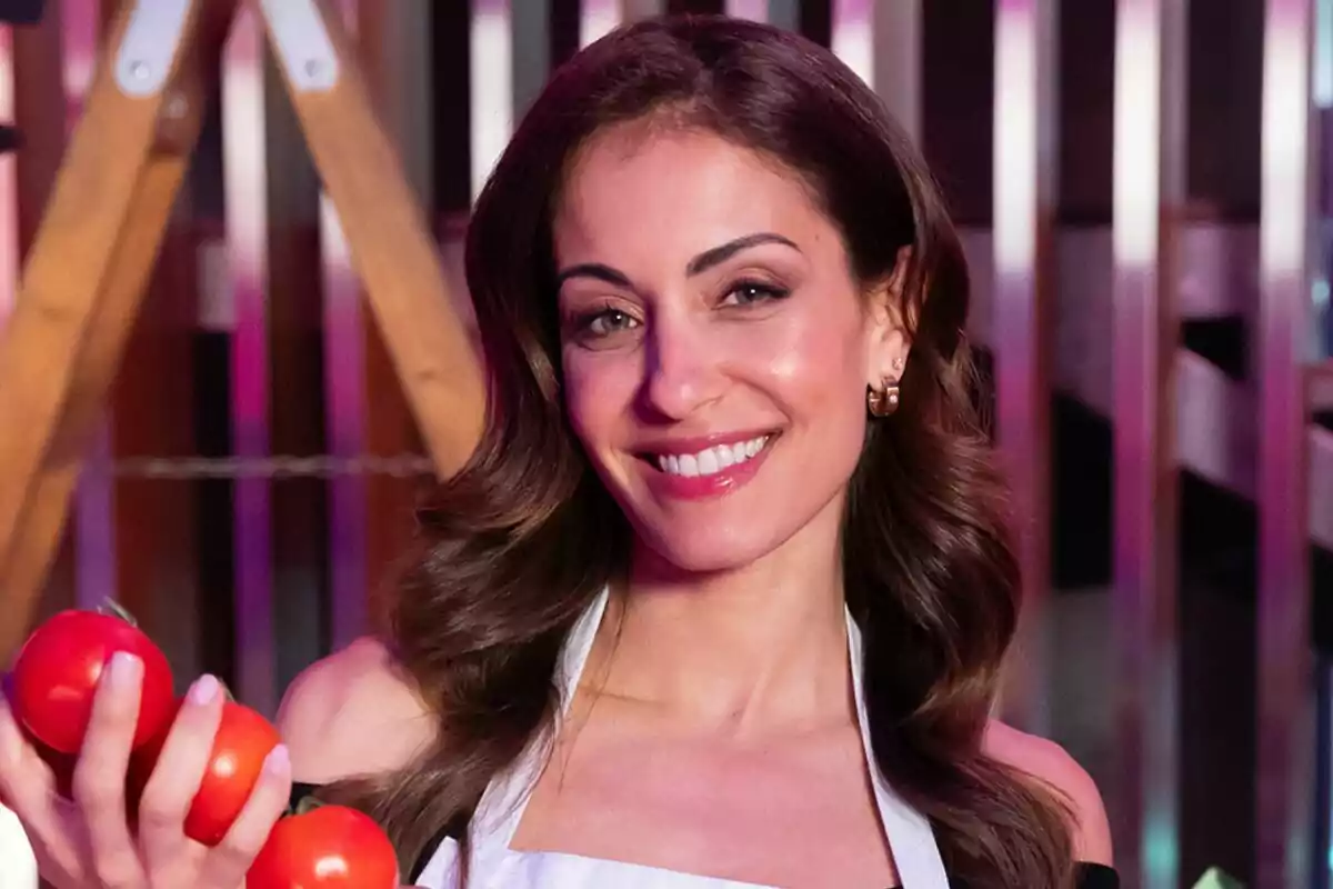 Hiba Abouk somrient amb davantal blanc i sostenint tomàquets a MasterChef Celebrity.