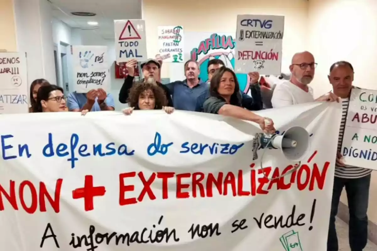 Treballadors de la Televisió de Galícia sostenint pancartes en una manifestació en defensa del servei públic i en contra de l'externalització.