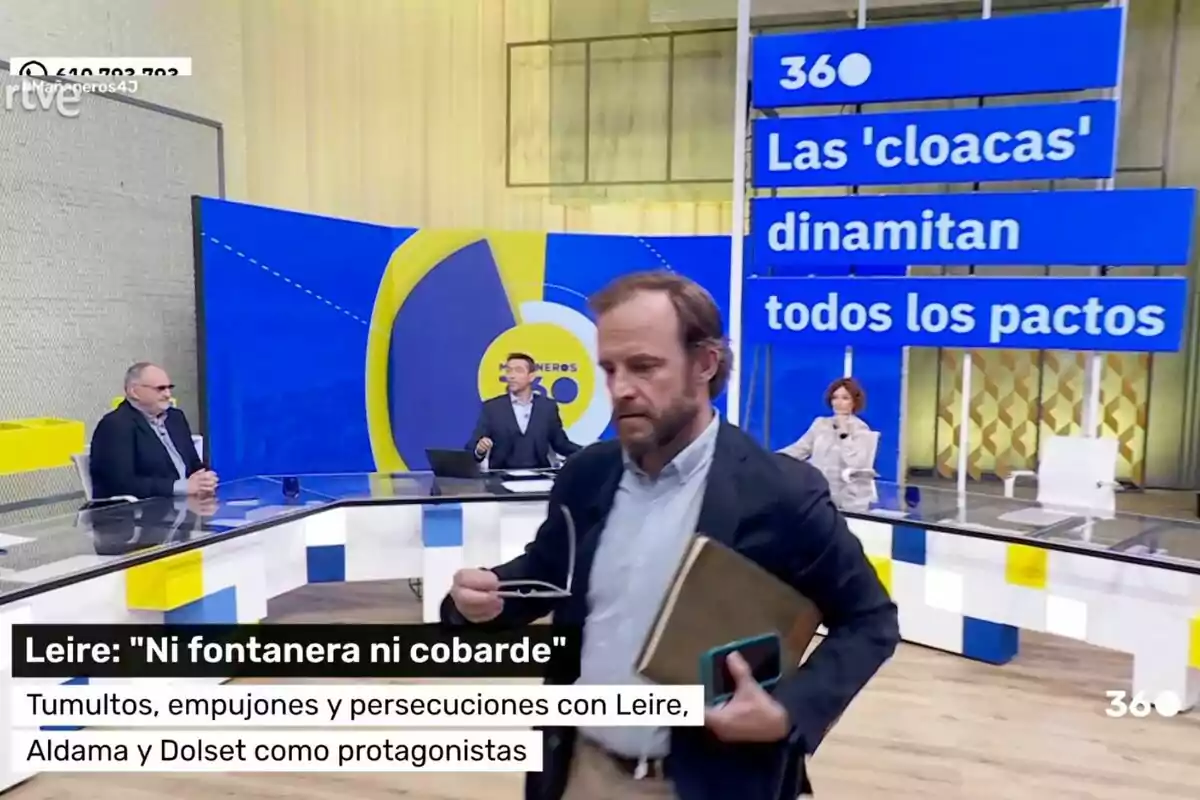 Chapu Apaolaza abandona amb una carpeta i un mòbil a la mà 'Mañaneros' amb diverses persones assegudes en una taula i un gran rètol blau que diu Les 'clavegueres' dinamiten tots els pactes