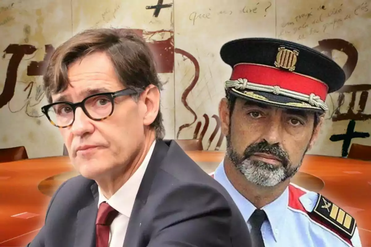 Dos homes en primer pla, un amb vestit i ulleres i l'altre amb uniforme de policia i gorra, amb un fons de taula rodona i escriptura a la paret.