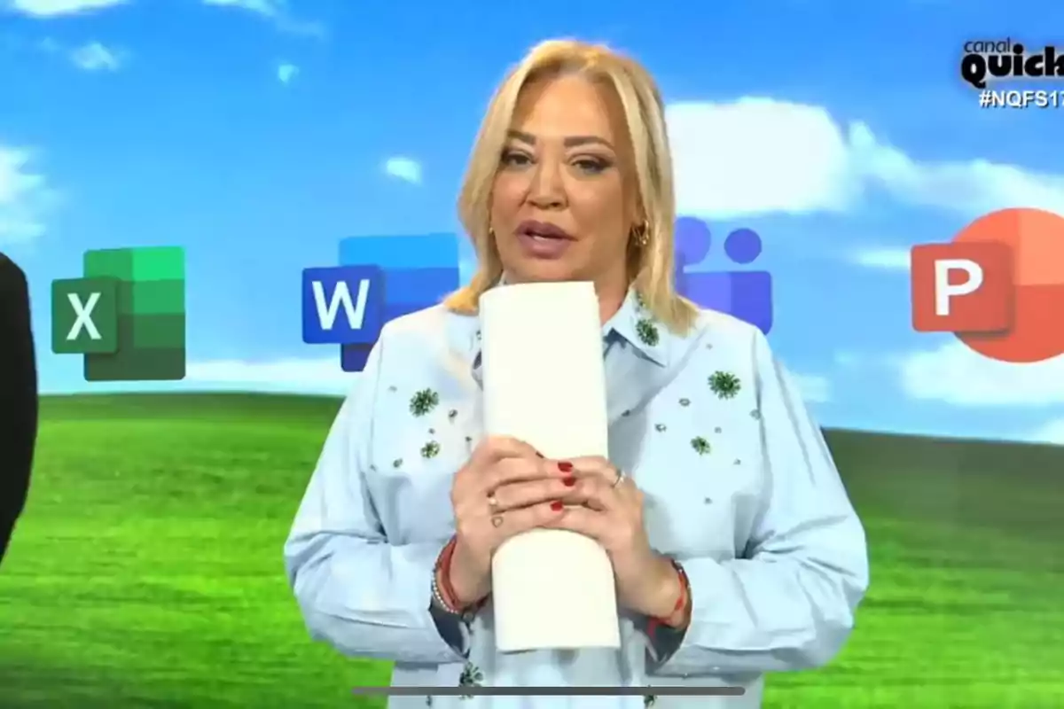 Belén Esteban sosteniendo un objeto blanco frente a un fondo con iconos de aplicaciones y un paisaje verde.