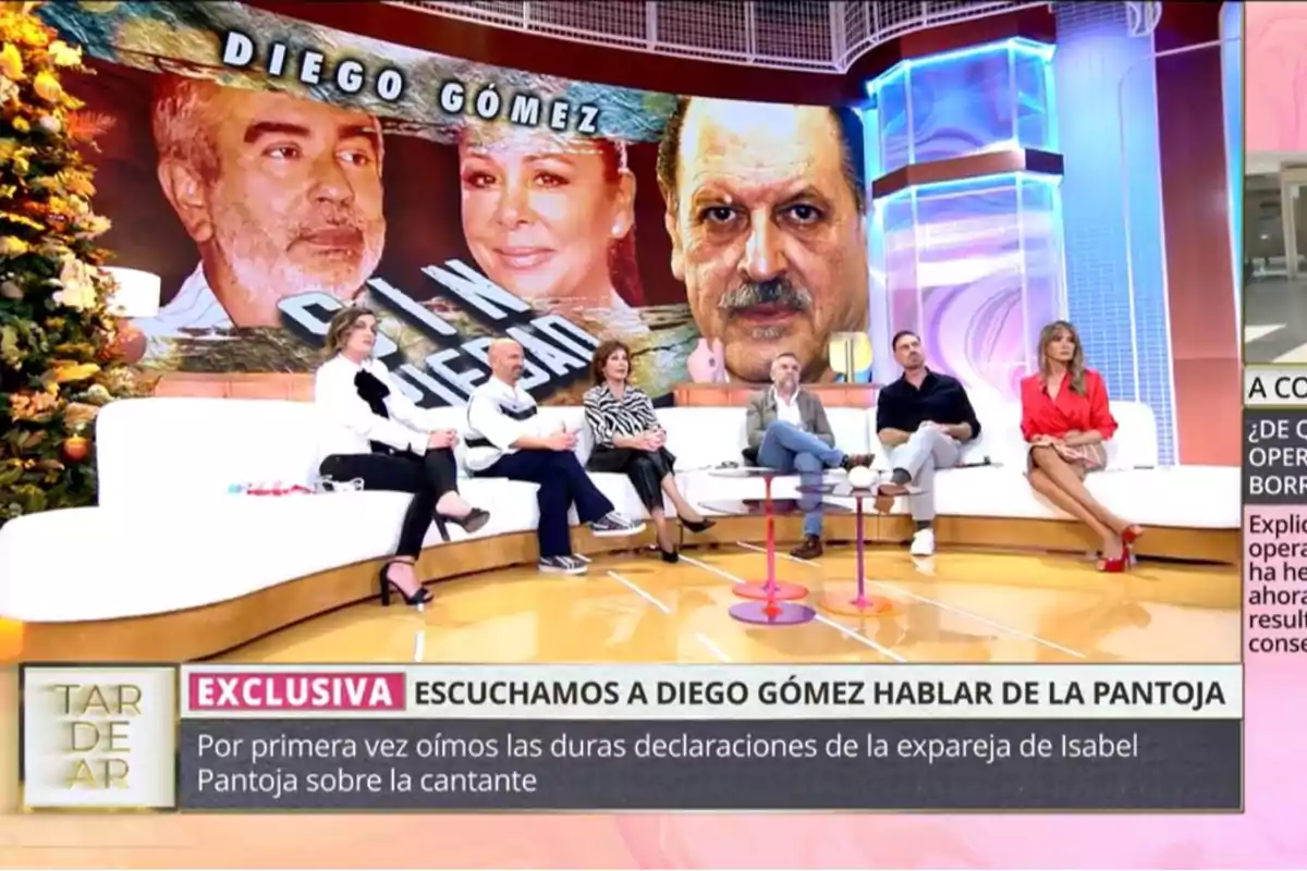 Un grup de persones assegudes en un plató de televisió amb una pantalla gran darrere que mostra imatges de dues persones i el text 