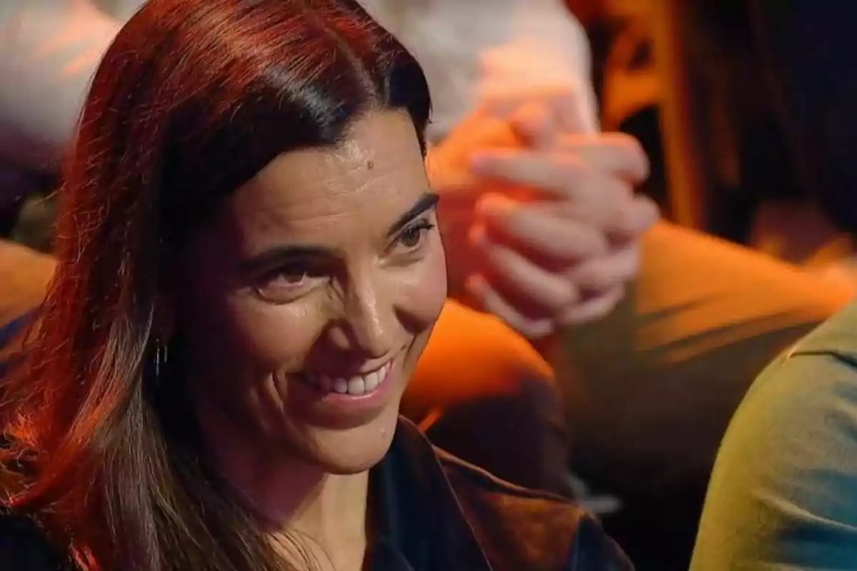 Una dona somrient en un ambient il·luminat amb llums càlides. Una dona somrient en un ambient il·luminat amb llums càlides.