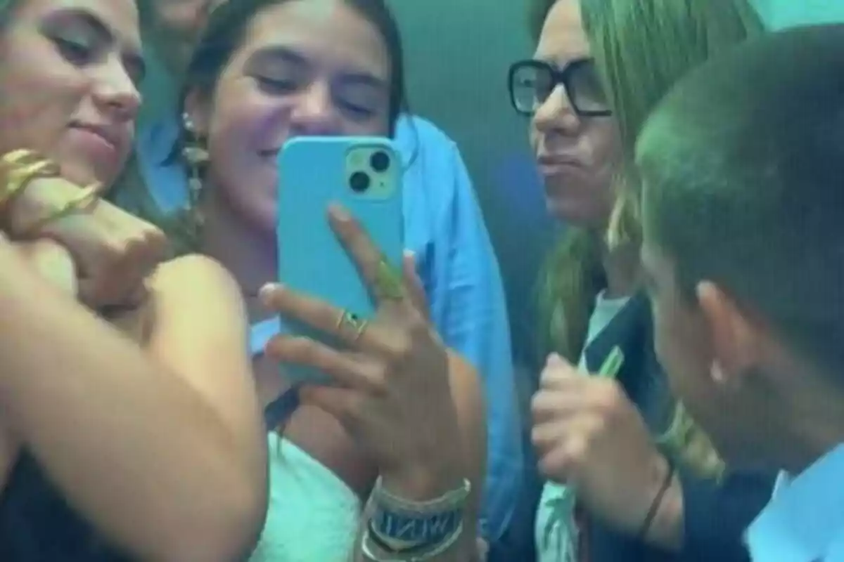 A group of people take a selfie in an elevator, everyone seems to be enjoying the moment.