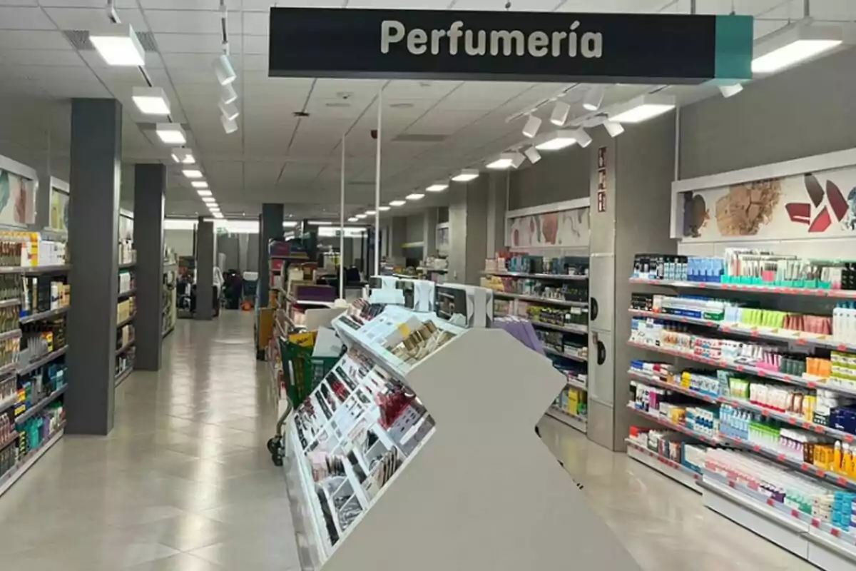Passadís d'una botiga amb prestatges plens de productes de perfumeria i cosmètica, il·luminat amb llums de sostre. Passadís d'una botiga amb prestatges plens de productes de perfumeria i cosmètica, il·luminat amb llums de sostre.