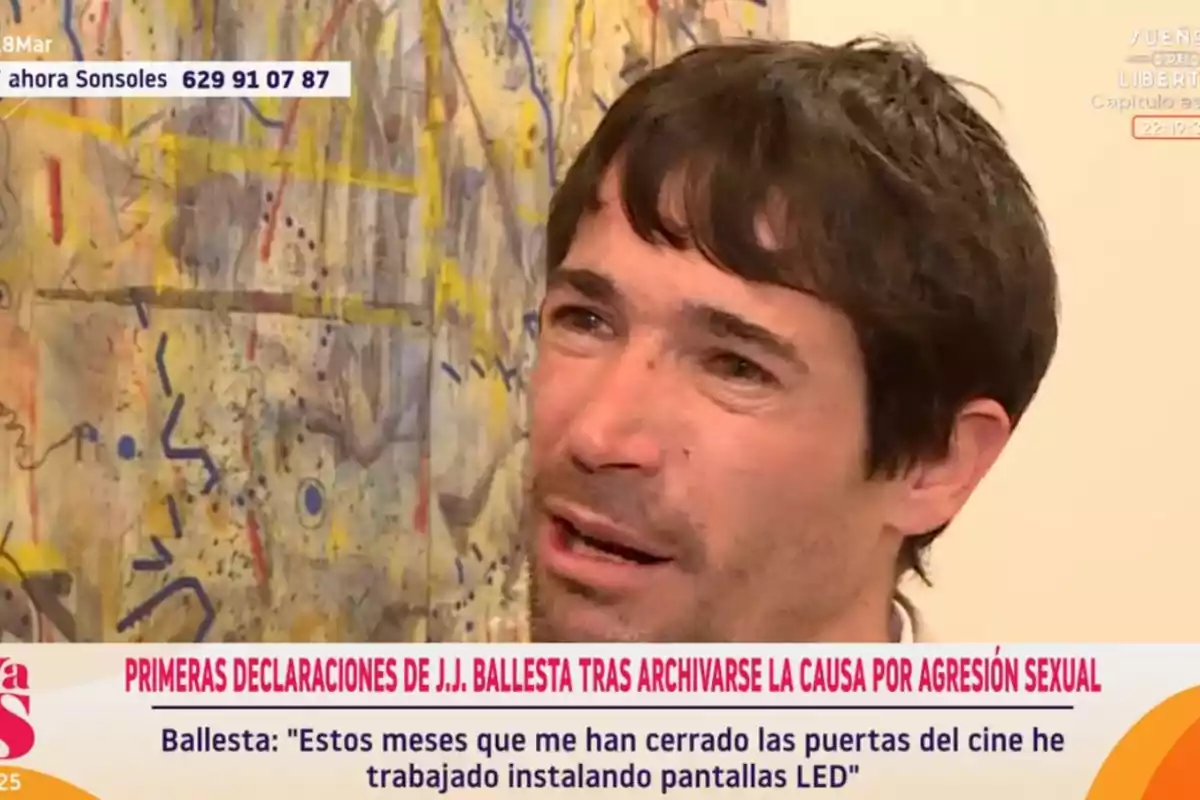 A man with dark hair appears in a television interview, with an abstract art background and on-screen text mentioning statements about a legal case. A man with dark hair appears in a television interview, with an abstract art background and on-screen text mentioning statements about a legal case.