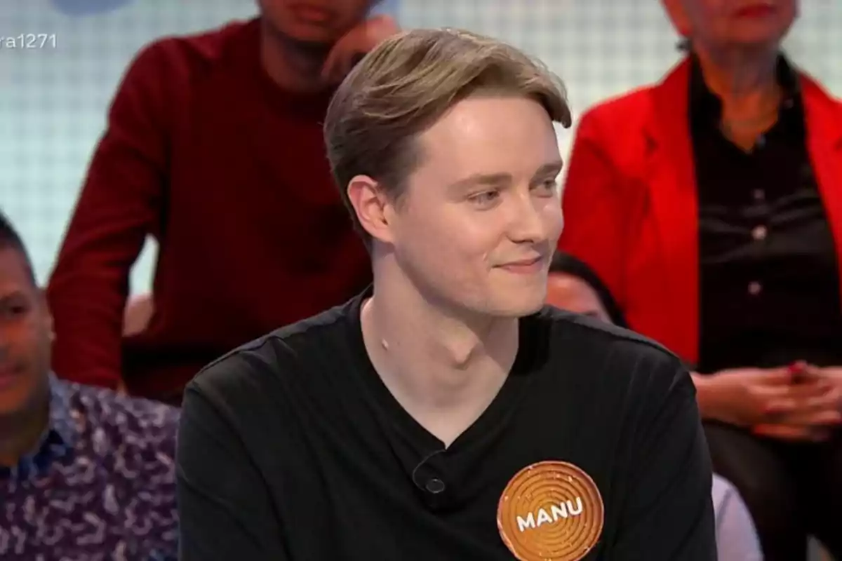 A young man wearing a black T-jersey with a tag that says A young man wearing a black T-jersey with a tag that says