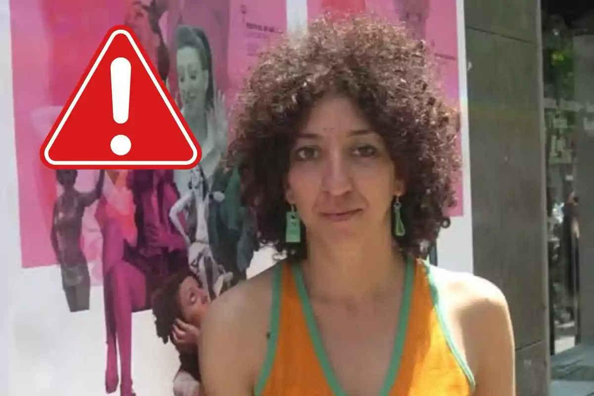 Mónica Cervera con cabello rizado y aretes verdes está frente a un cartel colorido con un símbolo de advertencia superpuesto.