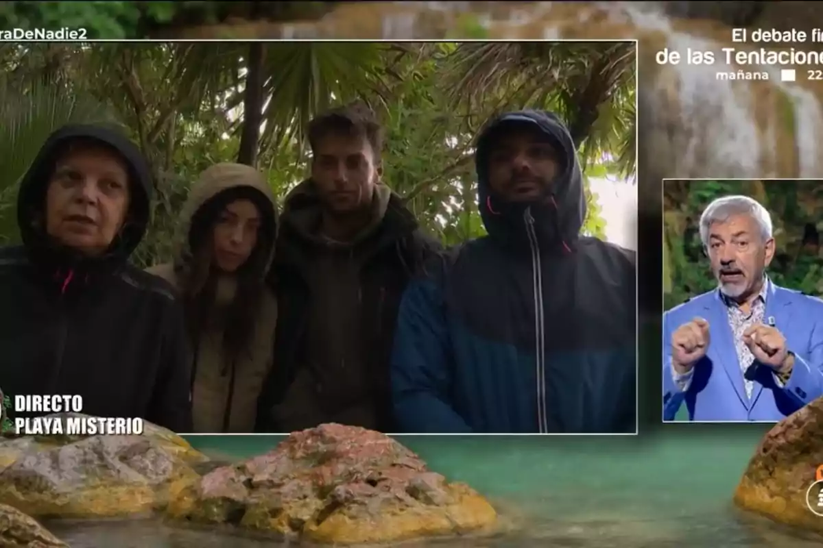 A group of people in warm clothing is in a jungle setting while an older man appears in an inset speaking in a television studio. A group of people in warm clothing is in a jungle setting while an older man appears in an inset speaking in a television studio.