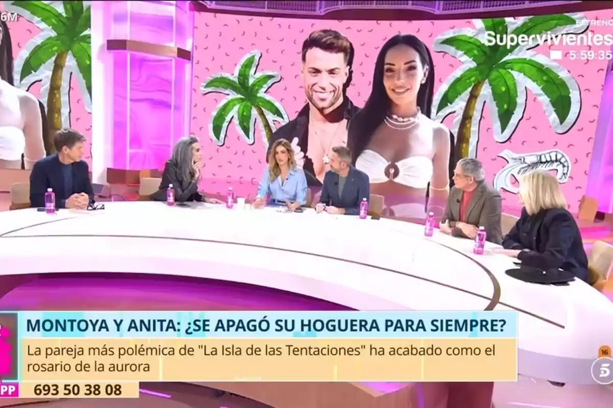 A group of people is sitting around a table on a television set with a colorful background featuring palm trees and two large figures, while they discuss a topic related to a reality TV show. A group of people is sitting around a table on a television set with a colorful background featuring palm trees and two large figures, while they discuss a topic related to a reality TV show.