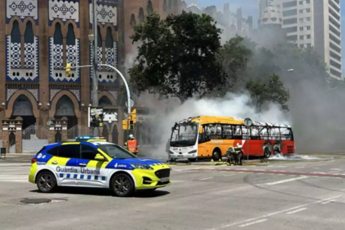 Plànol general d'un autobús cremant en flames al carrer Marina de Barcelona