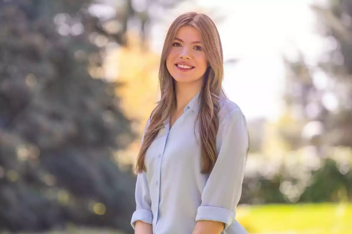 Infanta Sofía smiles while standing outdoors with a background of trees and natural light. Infanta Sofía smiles while standing outdoors with a background of trees and natural light.
