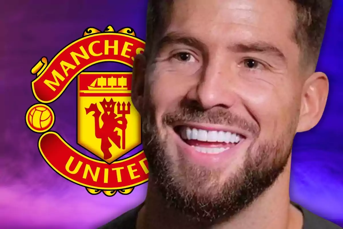 Un home somrient amb barba davant del logo del Manchester United sobre un fons porpra.