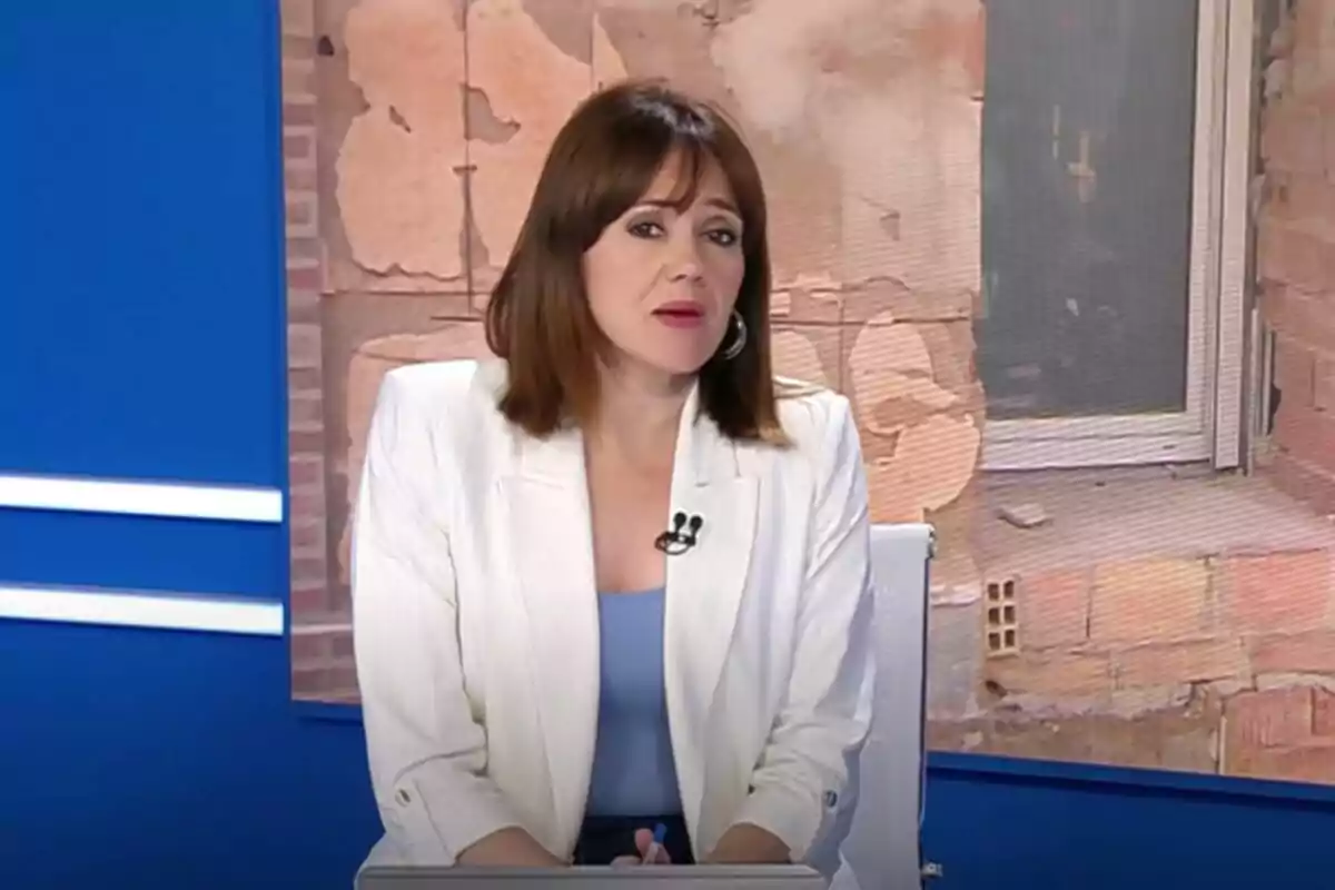 Inma Canet de cabell castany i llis amb jaqueta blanca i brusa blava asseguda en un estudi de televisió de l'Informatiu Territorial de RTVE a València amb fons de paret de maons i pantalla blava Inma Canet de cabell castany i llis amb jaqueta blanca i brusa blava asseguda en un estudi de televisió de l'Informatiu Territorial de RTVE a València amb fons de paret de maons i pantalla blava