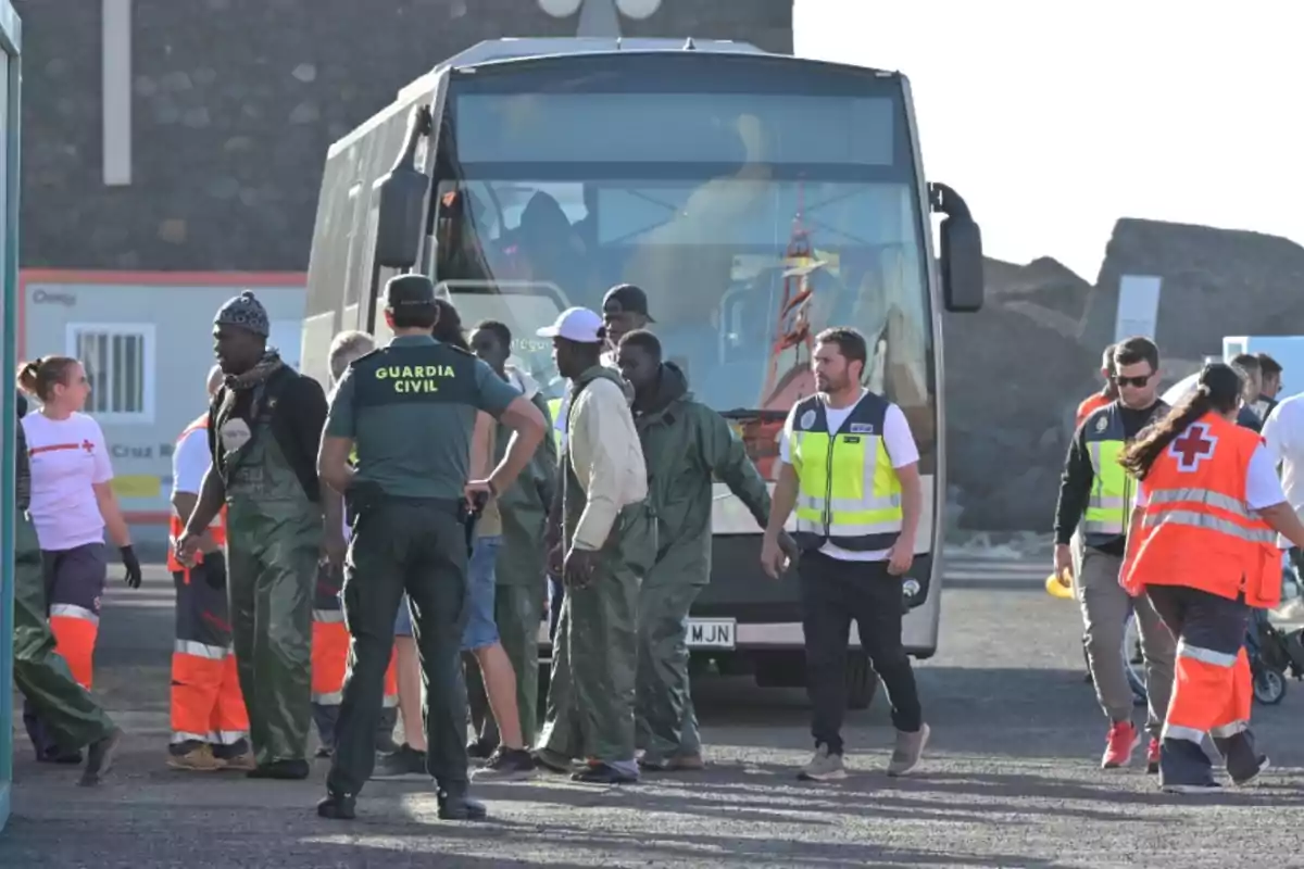 Un grup de persones, incloent-hi membres de la Guàrdia Civil i de la Creu Roja, són al voltant d'un autobús.