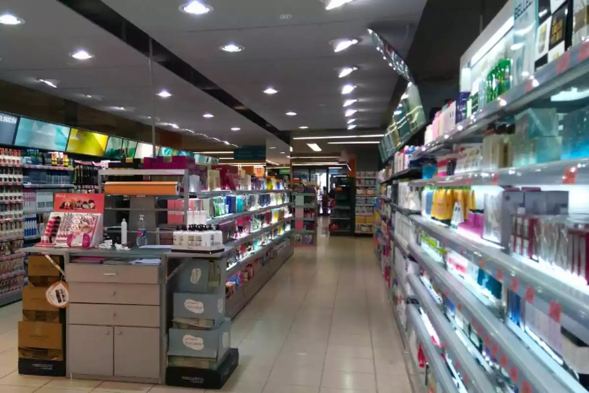 Pasillo de una tienda de Mercadona con estantes llenos de productos de belleza y cuidado personal iluminados por luces en el techo.
