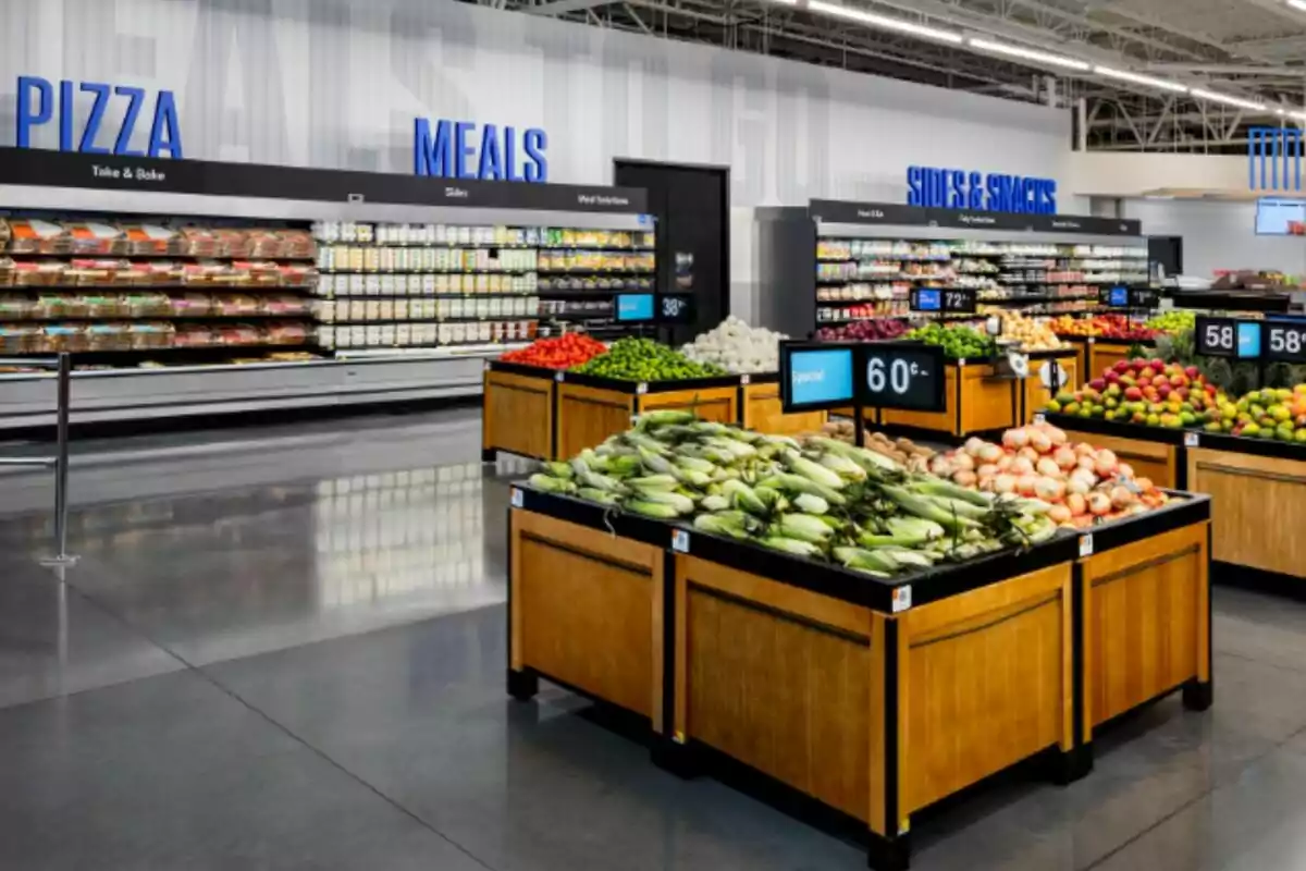 A supermarket section with shelves of fresh produce like corn, onions, and fruits, next to an area of prepared meals and pizzas.