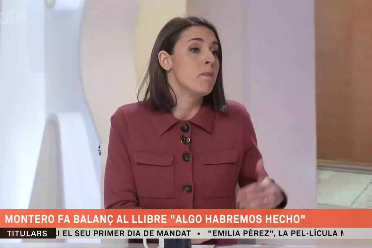 Una persona amb jaqueta vermella està parlant en un programa de televisió, amb un text a la part inferior que esmenta un llibre titulat "Alguna cosa haurem fet".