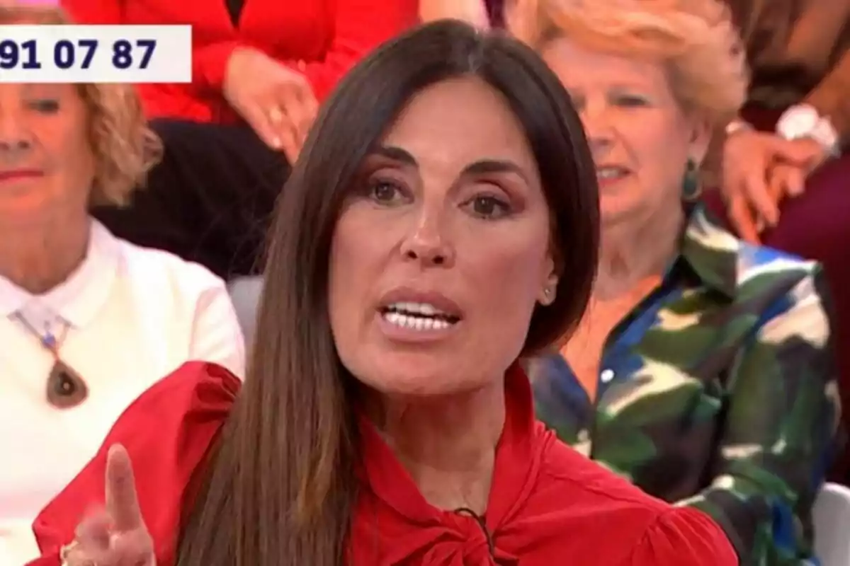 Isabel Rábago amb cabell llarg i fosc està parlant a Y ahora Sonsoles, vestida amb una brusa vermella, mentre altres persones estan assegudes darrere d'ella.