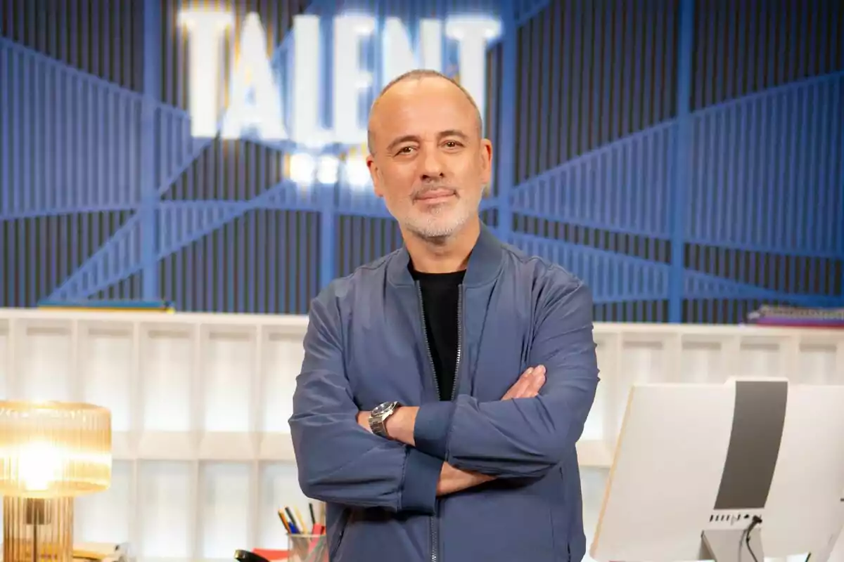 Javier Gutiérrez de pie con los brazos cruzados frente a un fondo que dice Javier Gutiérrez de pie con los brazos cruzados frente a un fondo que dice