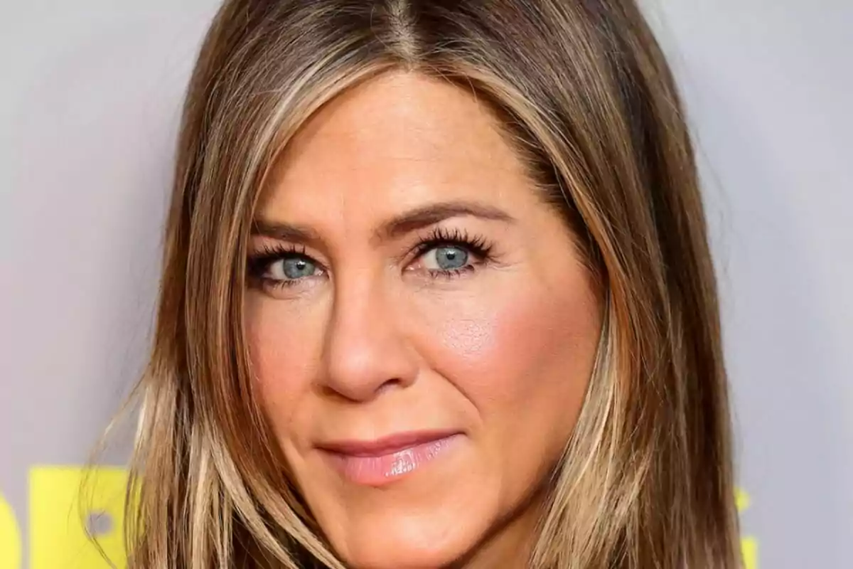 Primer plano de Jennifer Aniston con rostro sonriente mirando a cámara. Primer plano de Jennifer Aniston con rostro sonriente mirando a cámara.