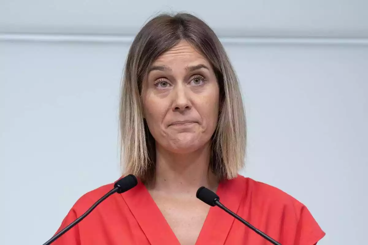 Primer pla de la líder dels comuns a Catalunya, Jéssica Albiach, amb un vestit vermell i cara d'incredulitat