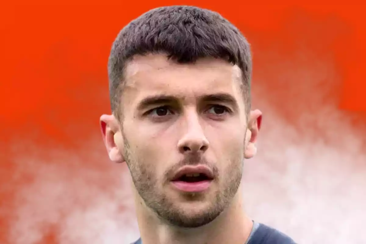 Young man with short hair and light beard against a blurred orange background