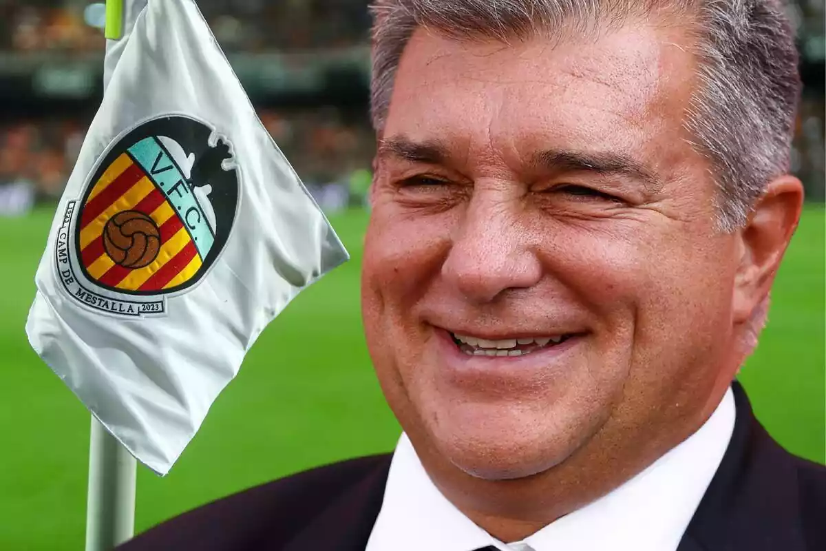 Joan Laporta smiling next to a pennant at the Mestalla Stadium