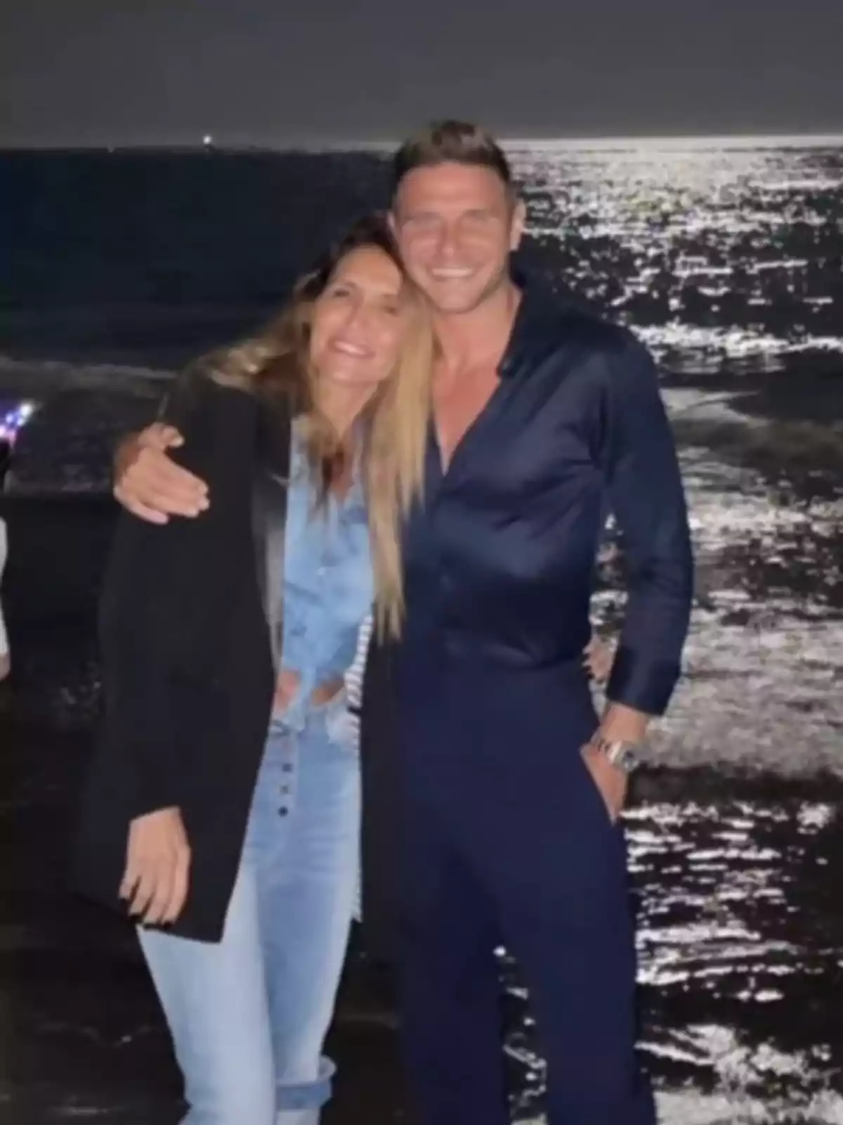 Joaquín Sánchez i Susana Saborido somrients posant a la platja durant la nit amb el mar il·luminat per la lluna al fons. Joaquín Sánchez i Susana Saborido somrients posant a la platja durant la nit amb el mar il·luminat per la lluna al fons.