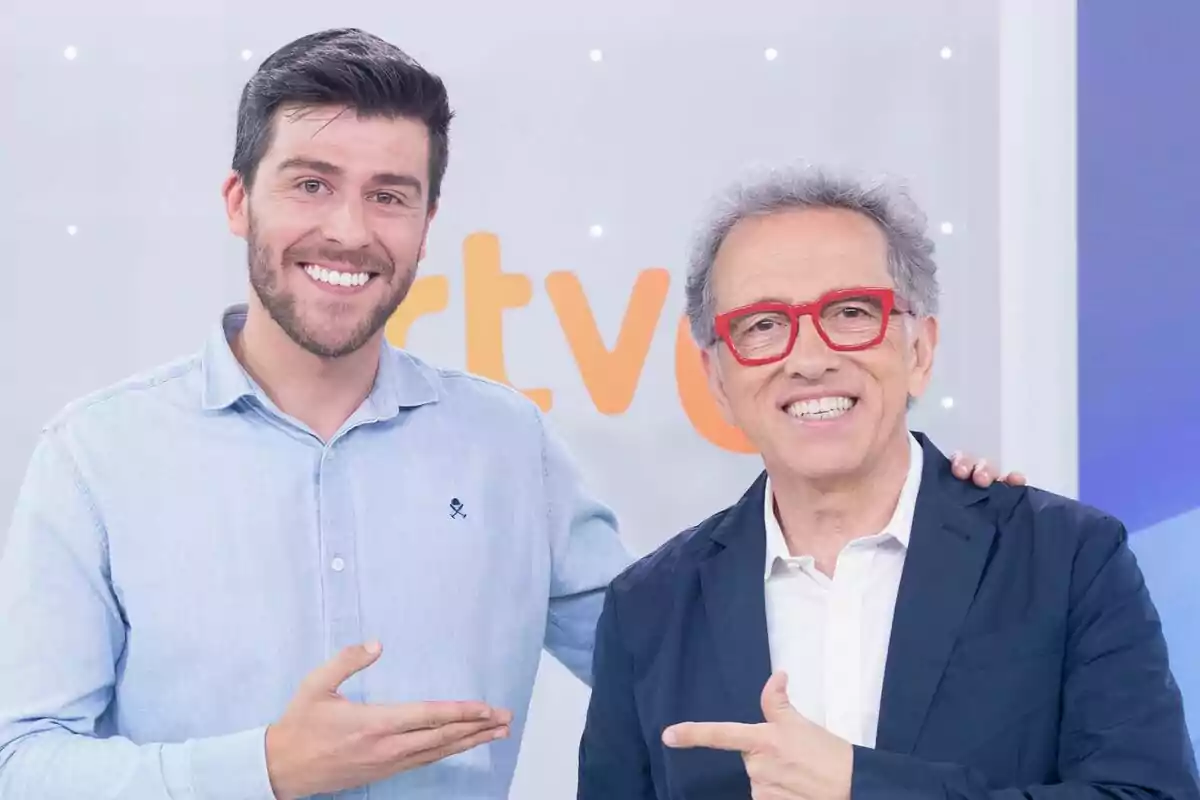 Rodrigo Vázquez i Jordi Hurtado somrients posen junts a la presentació de Saber i Guanyar, un porta ulleres vermelles i tots dos es senyalen mútuament. Rodrigo Vázquez i Jordi Hurtado somrients posen junts a la presentació de Saber i Guanyar, un porta ulleres vermelles i tots dos es senyalen mútuament.