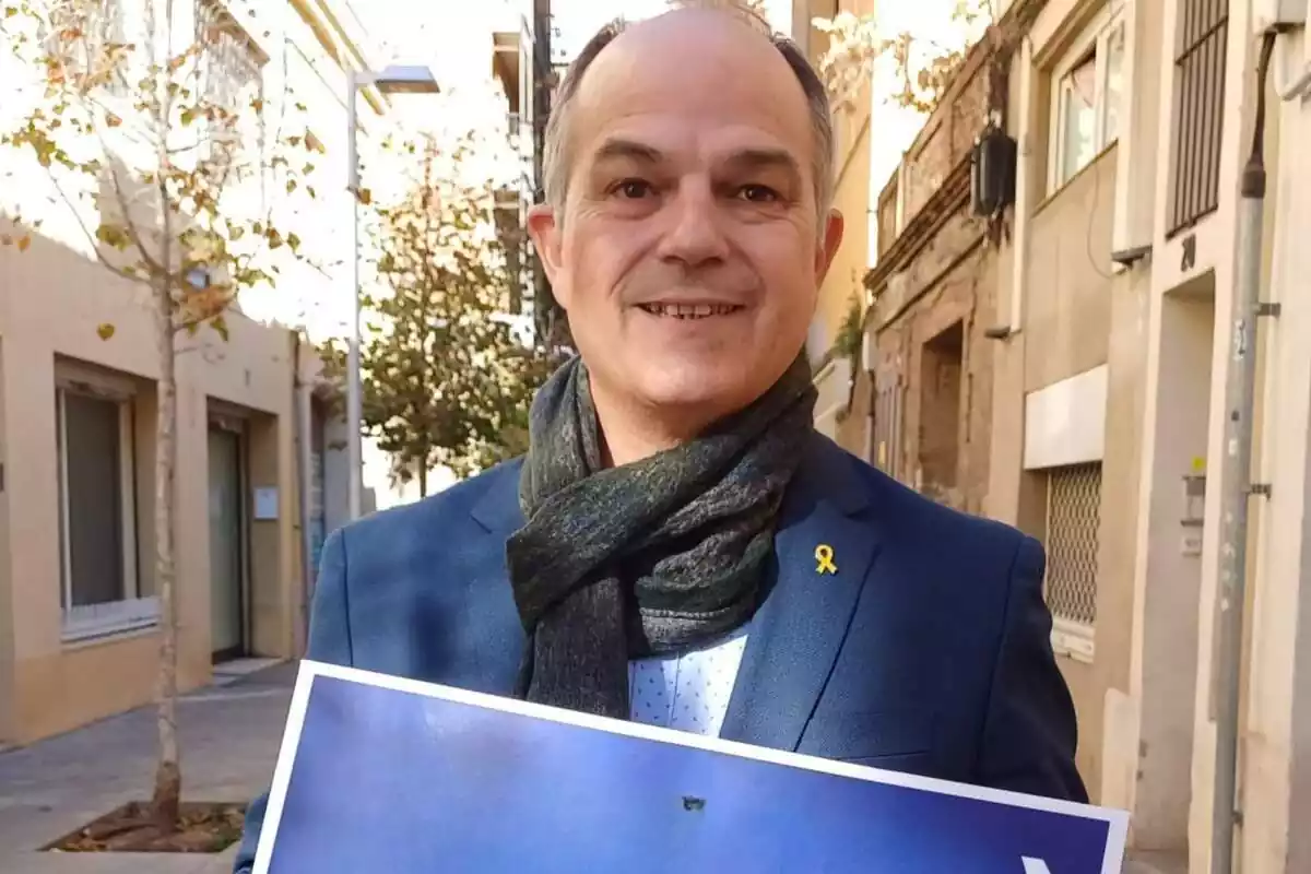 El polític català Jordi Turull, molt somrient, sostenint un cartell amb les mans