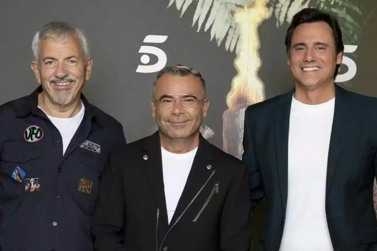 Carlos Sobera, Jorge Javier Vázquez i Ion Aramendi somrients posen junts davant d’un fons fosc amb el logotip d’un canal de televisió i una torxa de Supervivientes encesa. Carlos Sobera, Jorge Javier Vázquez i Ion Aramendi somrients posen junts davant d’un fons fosc amb el logotip d’un canal de televisió i una torxa de Supervivientes encesa.