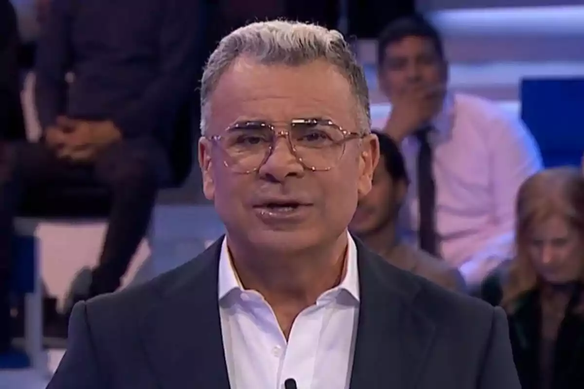 Jorge Javier Vázquez amb ulleres i cabell canós està parlant en un estudi de televisió amb persones assegudes al fons a Hi ha una cosa que et vull dir.