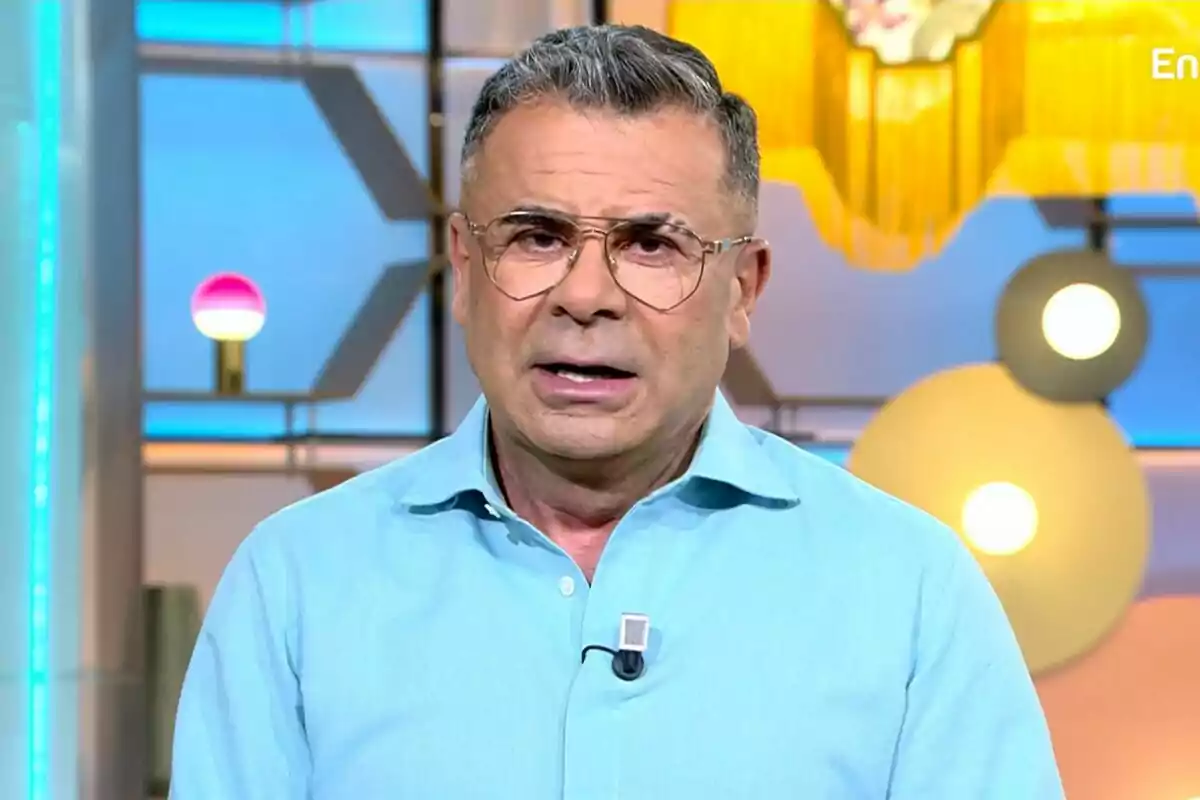 Jorge Javier Vázquez amb ulleres i camisa blava clar en un estudi de televisió amb llums i decoracions de fons a El Diario de Jorge.