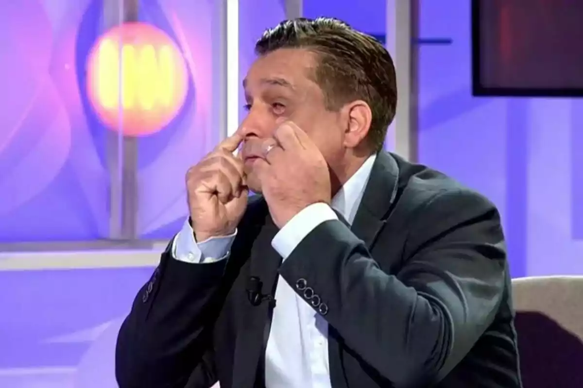José Manuel Saborido en un estudi de televisió a Codi 10 està assenyalant els seus ulls amb ambdues mans mentre porta posat un vestit fosc. José Manuel Saborido en un estudi de televisió a Codi 10 està assenyalant els seus ulls amb ambdues mans mentre porta posat un vestit fosc.