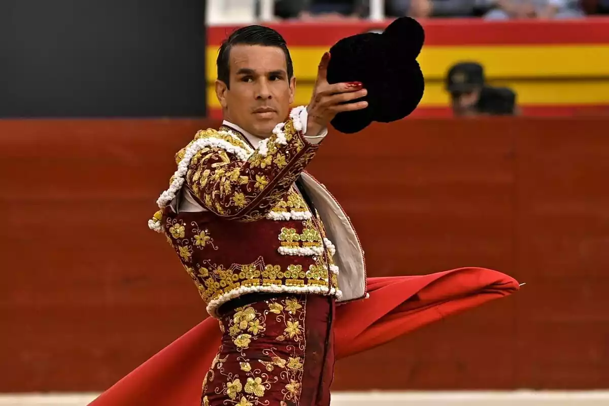 José María Manzanares amb un vestit de torero vermell i un barret a la mà José María Manzanares amb un vestit de torero vermell i un barret a la mà