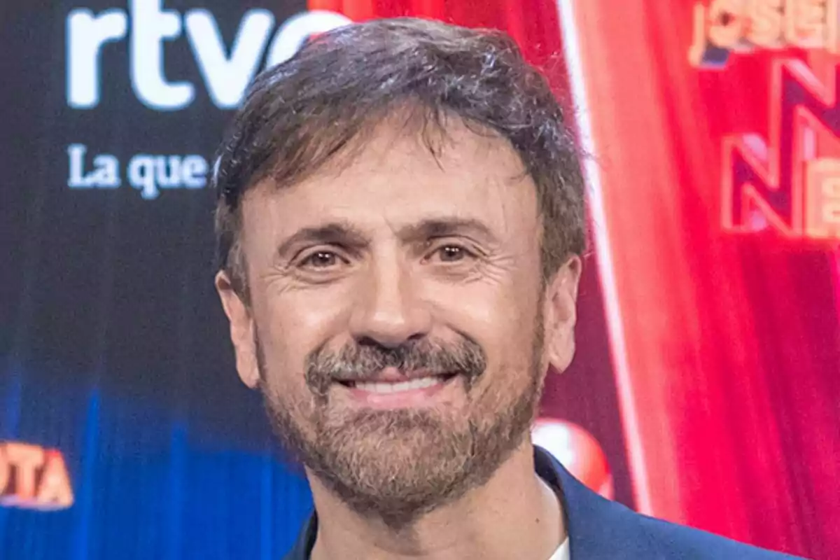 José Mota sonriente con barba y cabello castaño claro en la presentación de José Mota No News con fondo de logotipos y luces.