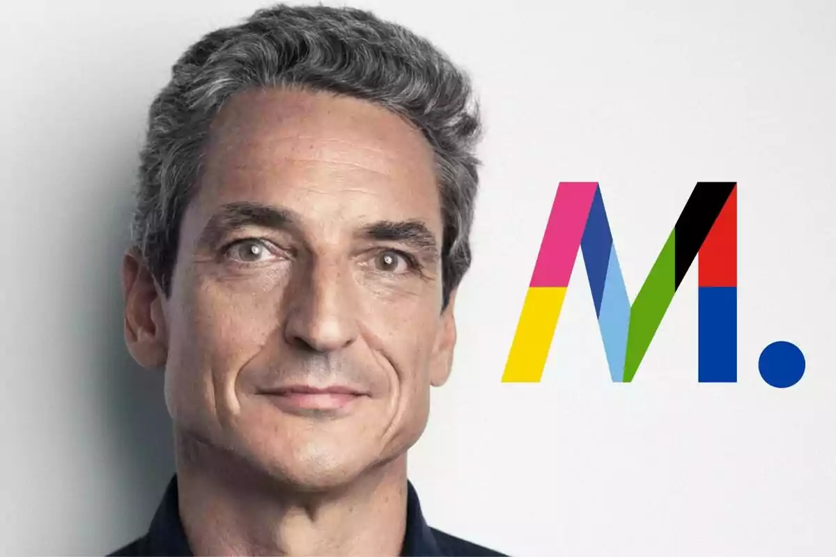 Juan Baixeras de cabello canoso y ojos claros mira al frente junto a un logotipo colorido con la letra "M" (Mediaset).