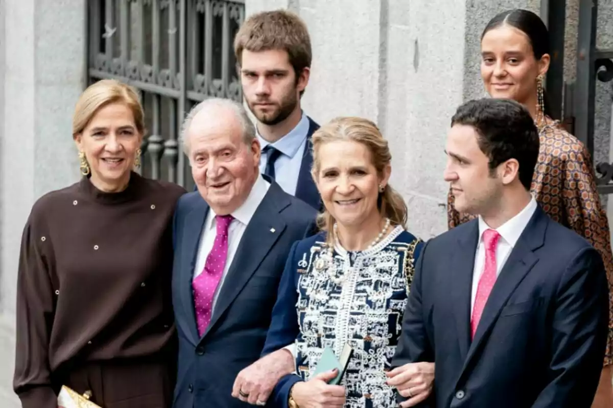 Un grup de persones posant juntes davant d'un edifici elegant. Un grup de persones posant juntes davant d'un edifici elegant.