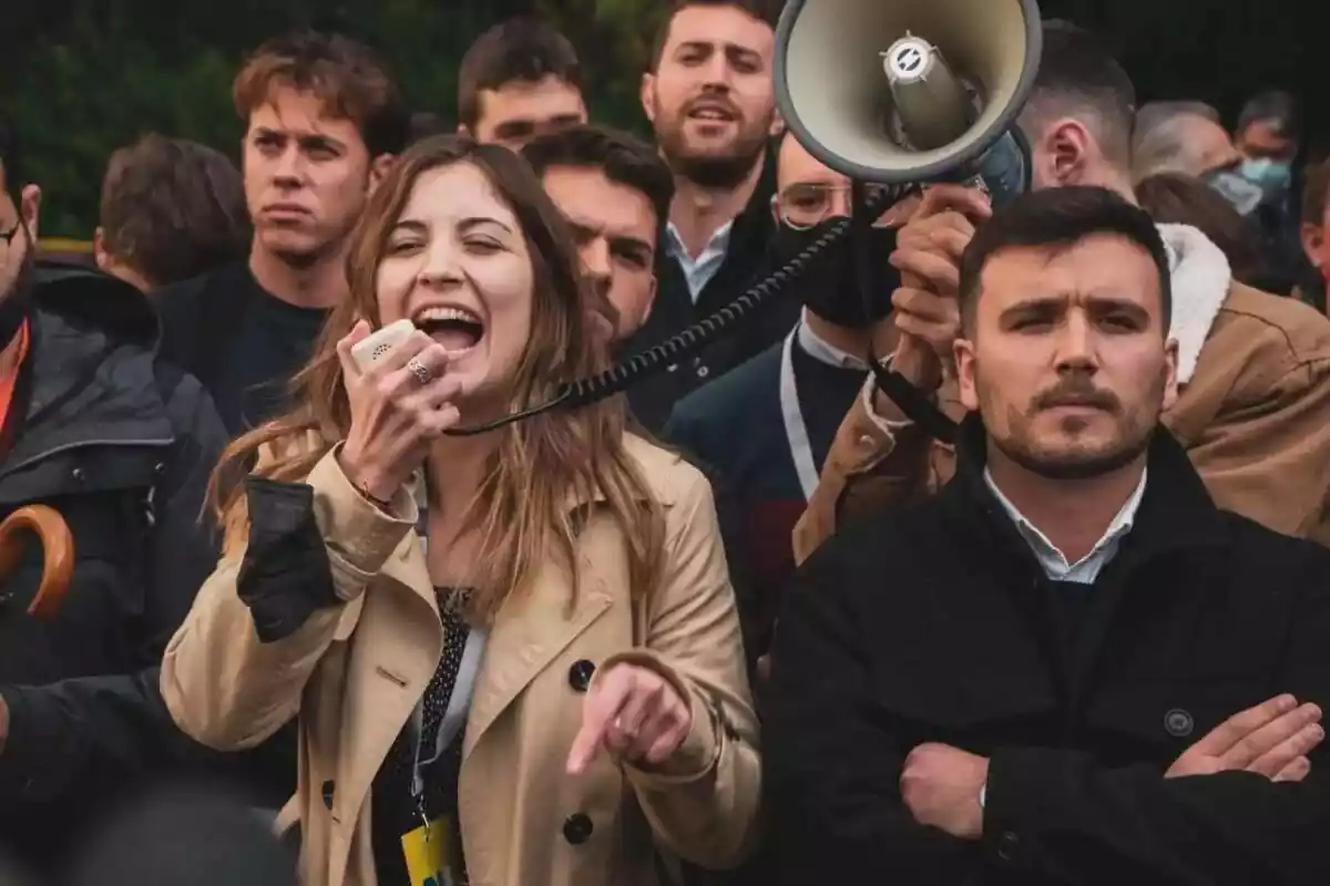 Diversos membres de S'ha Acabat protestant, amb dues persones en primer pla. Una és Júlia Calvet, que crida en un megàfon